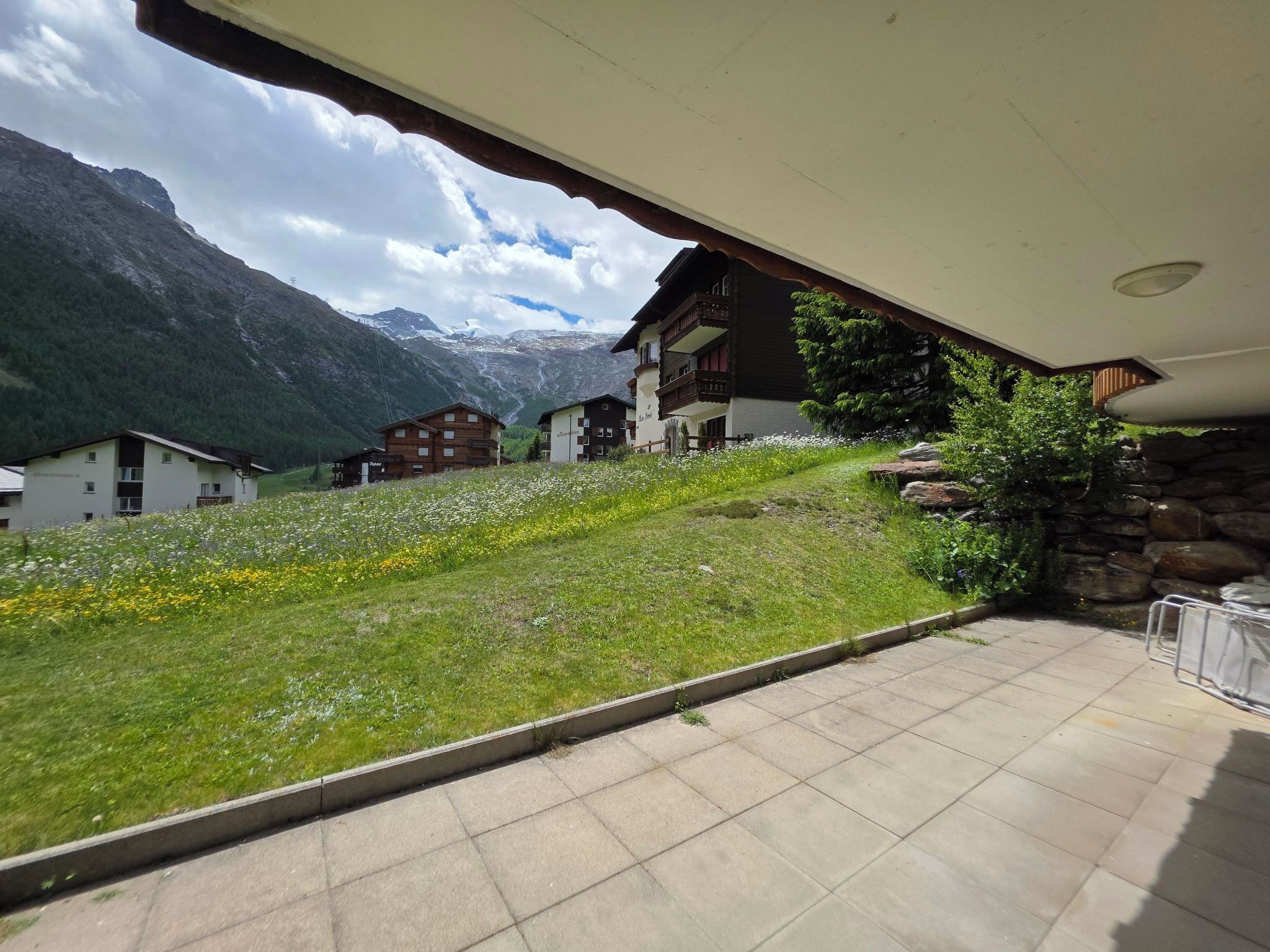 A hotel with a terrace overlooking a mountainous landscape.