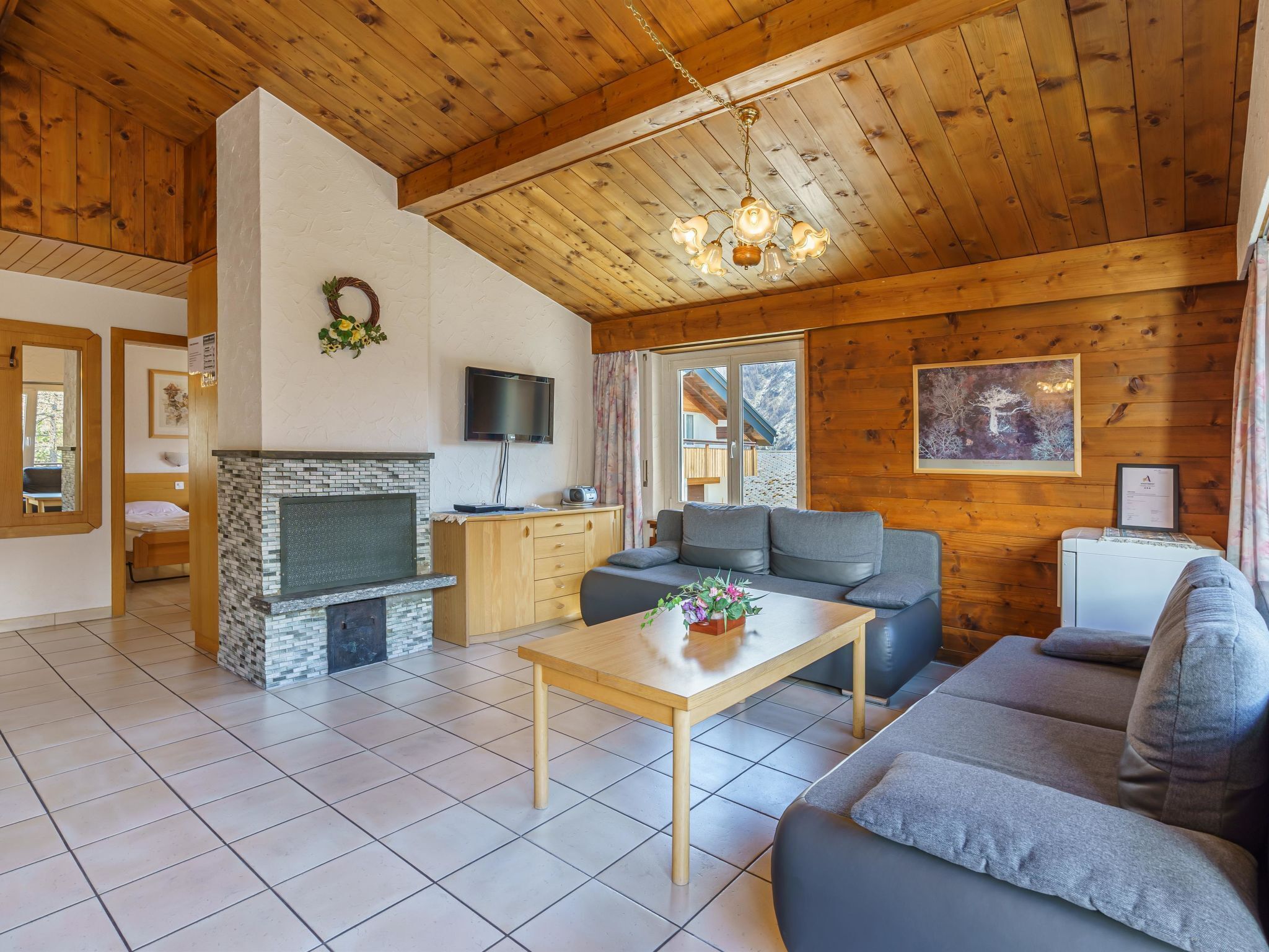 Ein gemütliches Wohnzimmer mit Kamin, Sofa und Fernseher.