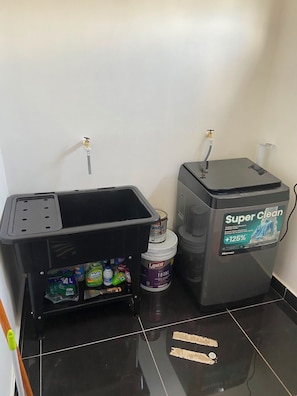 A bathroom with a black sink, a toilet, and a wall-mounted water heater.