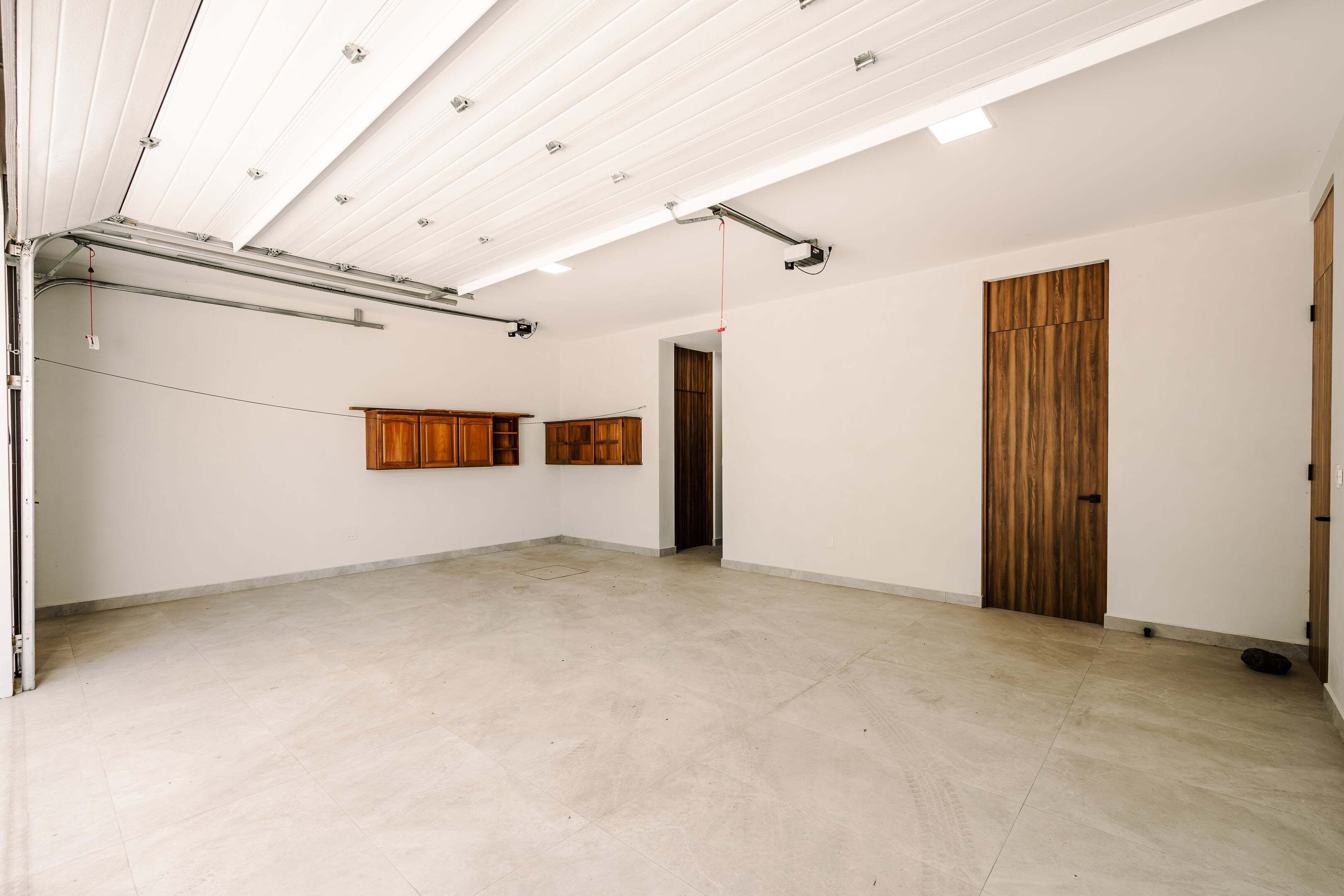 Une pièce spacieuse avec un plafond haut, des poutres apparentes et une grande porte en bois.