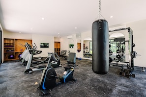 A gym with cardio machines, a punching bag, and weightlifting equipment.