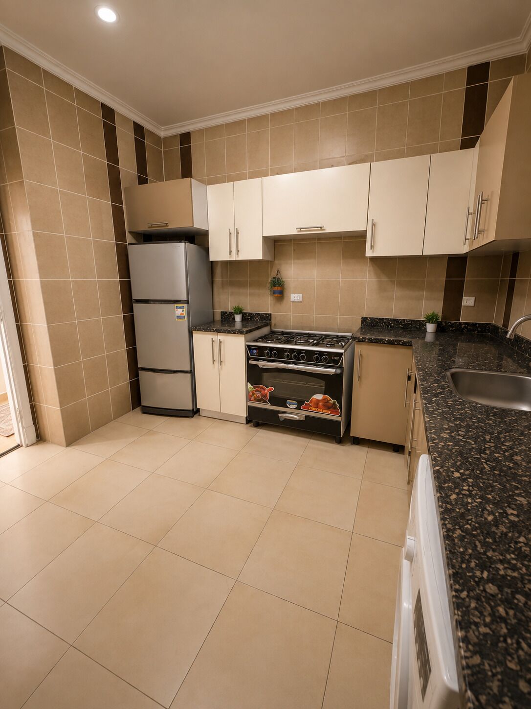 Eine Küche mit Herd, Backofen und Kühlschrank.