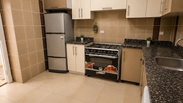 Eine Küche mit Herd, Backofen und Kühlschrank.