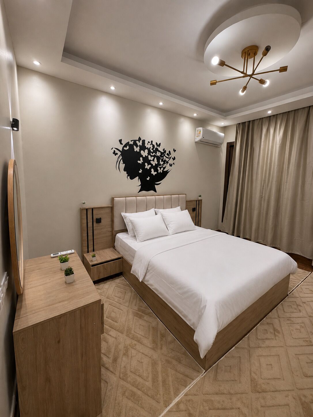 Une chambre moderne comprenant un lit, des tables de chevet, un climatiseur fixé au mur et un luminaire au plafond.