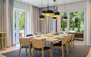 A dining area with a round table set for six, surrounded by chairs, with a view of greenery outside. - Villa Rijeka, Private villa with pool, Hvar Island (Hvar)