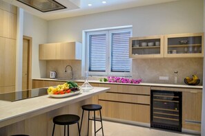 A modern kitchen with a central island, wooden cabinets, and a built-in dishwasher. - Villa Rijeka, Private villa with pool, Hvar Island (Hvar)