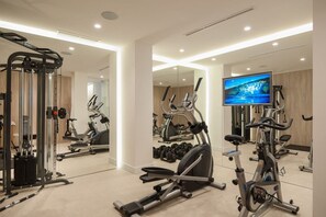 A modern gym with various exercise equipment, a television, and a large mirror. - Villa Tihana, Private villa with pool, Brac Island (Puntinak)