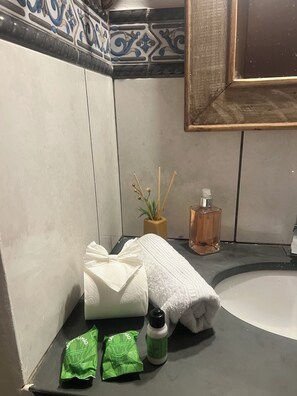 A bathroom with a white bathtub, a sink, a bottle of liquid soap, and two green sachets of soap. - Casa Aconchegante em Sao joao del Rei (São João del Rei)