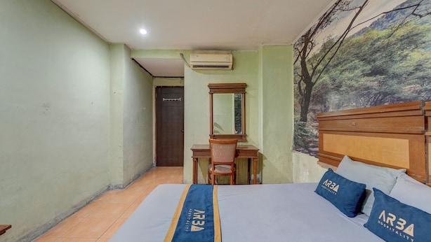 A bedroom with a bed, a desk, a chair, and a door.