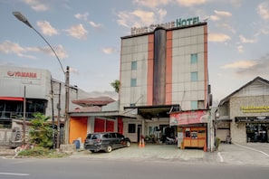 A hotel with a prominent sign, a Yamaha dealership, and a small food stall.
