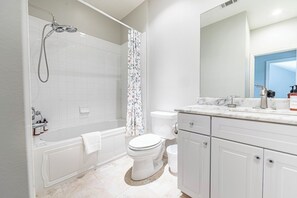 Un baño moderno con ducha, inodoro y tocador.
