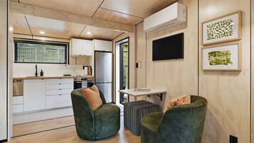 A modern interior with a kitchen, seating area, and artwork.