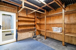A room with wooden shelving, a door, and a blue carpet.