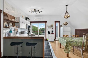 Une cuisine moderne dotée d’un îlot central, de tabourets de bar et d’un coin repas avec une table et des chaises.