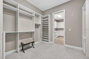 A walk-in closet with multiple shelves and a bench. - 3 bed house in Esplanade Lakewood Ranch Bradenton with private POOL and GOLF (Bradenton)