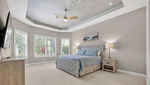 A bedroom with a bed, a ceiling fan, a TV, and a desk. - 3 bed house in Esplanade Lakewood Ranch Bradenton with private POOL and GOLF (Bradenton)