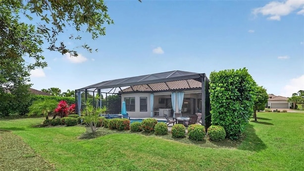 Une maison dotée d’un patio couvert, d’une piscine et d’un jardin bien entretenu.