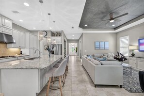 A modern kitchen with a large island, bar stools, and a built-in oven. - 3 bed house in Esplanade Lakewood Ranch Bradenton with private POOL and GOLF (Bradenton)