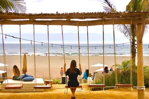 Ein Strand mit einer Schaukel und Blick aufs Meer.