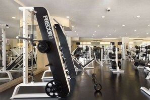 A gym with various exercise equipment, including a black PRECOR USA machine, weight racks, and cardio machines. - Villa Del Arco Beach Resort (Cabo San Lucas)