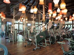 A gym with exercise equipment, including treadmills and weight machines, and large windows allowing natural light. - Three Bedroom Estates Villa with Platinum Benefits (Nuevo Nayarit)