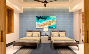Una camera d'hotel con un letto grande, due comodini, una ventola a soffitto e un'ampia pittura astratta appesa al muro.