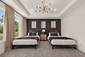 Ein Schlafzimmer mit zwei Betten, einem Nachttisch, einer Lampe und einem Bild an der Wand.