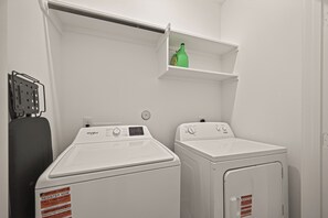 A laundry room with two white Whirlpool washers and a metal drying rack. - Stunning Designer Home Minutes to NRG, Medical Center & Downtown Sleeps 9 (Houston)