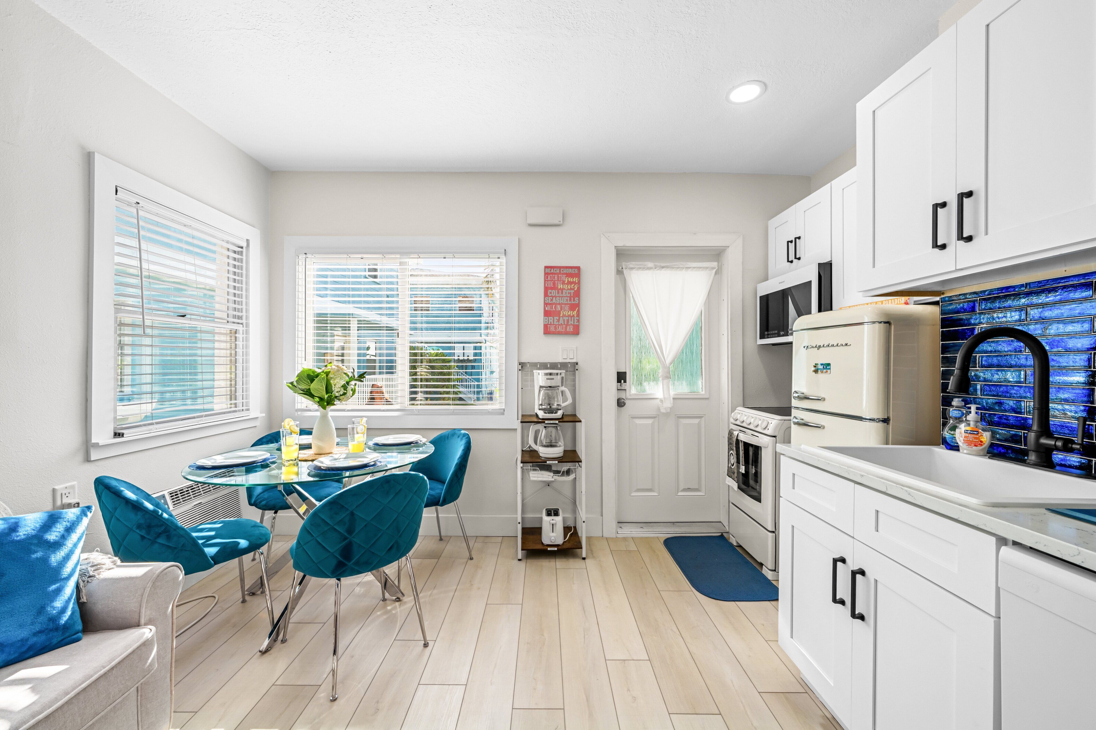 A modern kitchen with white cabinets, a built-in microwave, and a coffee maker.