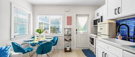 A modern kitchen with white cabinets, a built-in microwave, and a coffee maker.