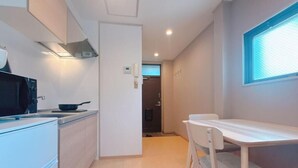 A modern kitchen with a microwave, stove, and cabinets. There is a dining area with a table and chairs.