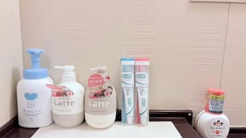 A bathroom counter with various toiletries including a shampoo bottle, conditioner, and toothbrushes.