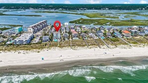 An aerial view of a coastal residential area with beachfront properties, a marina, and a red location marker. - Sea Y'all Soon - Oceanfront in Garden City Beach (Garden City Beach)