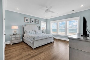 A bedroom with a bed, bedside tables, a ceiling fan, and a window with blinds. - Sea Y'all Soon - Oceanfront in Garden City Beach (Garden City Beach)