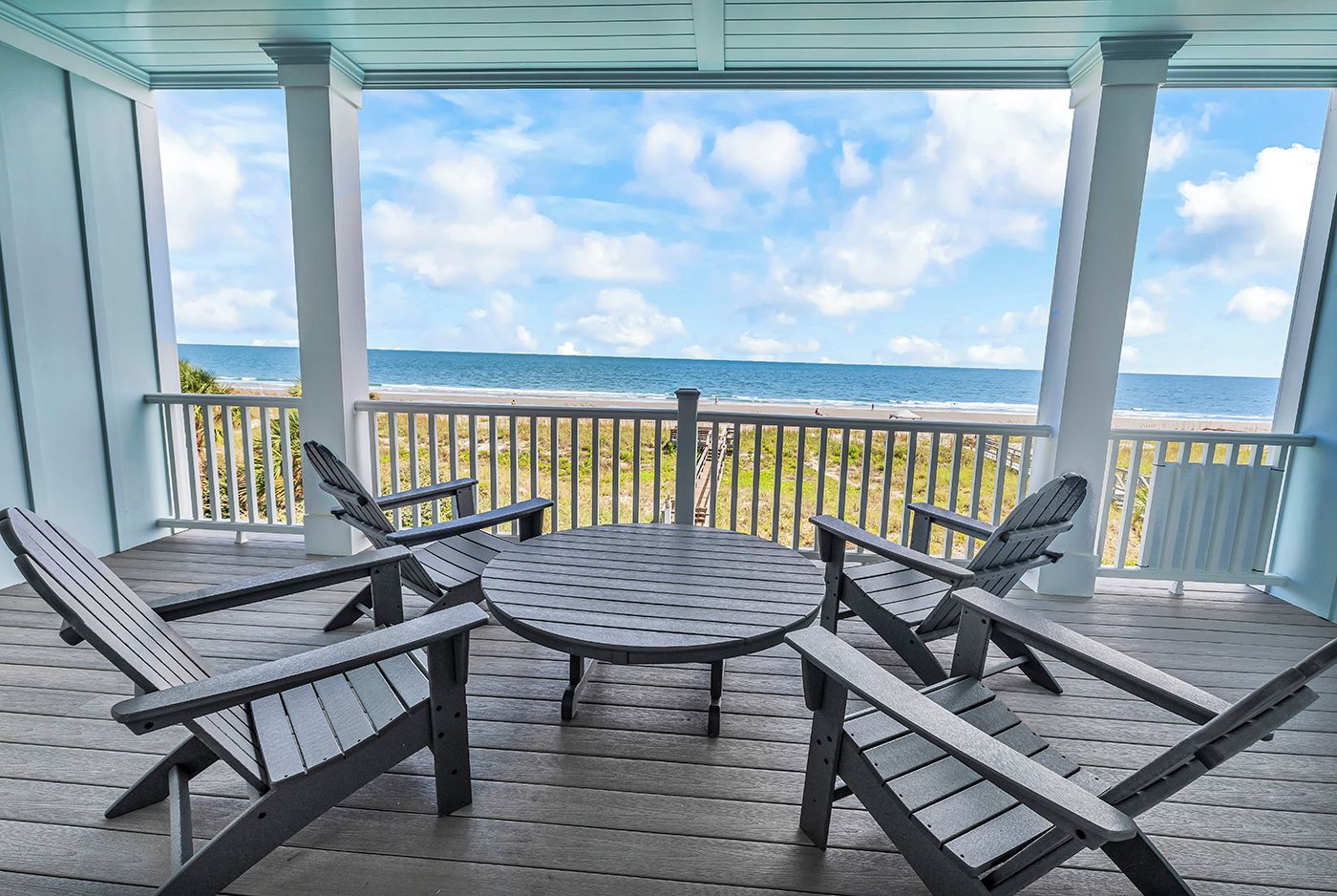 A covered outdoor seating area with a view of the ocean.