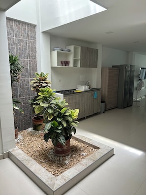 A modern kitchen with a built-in stove, wooden cabinets, and a large refrigerator.