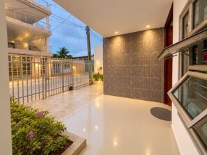 A modern building with a gated entrance, a flat roof, and a clean, tiled floor.