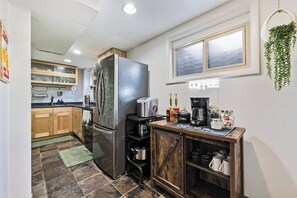 A compact kitchen with a refrigerator, coffee maker, and a window with a view. - *New* Gorgeous Open Space, Perfect Location, Private Apartment! (Millcreek)