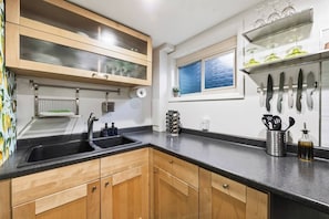A kitchen with wooden cabinets, a double sink, a window with a view, and a knife rack. - *New* Gorgeous Space w/Big Rooms, Perfect Location - Apartment (Millcreek)