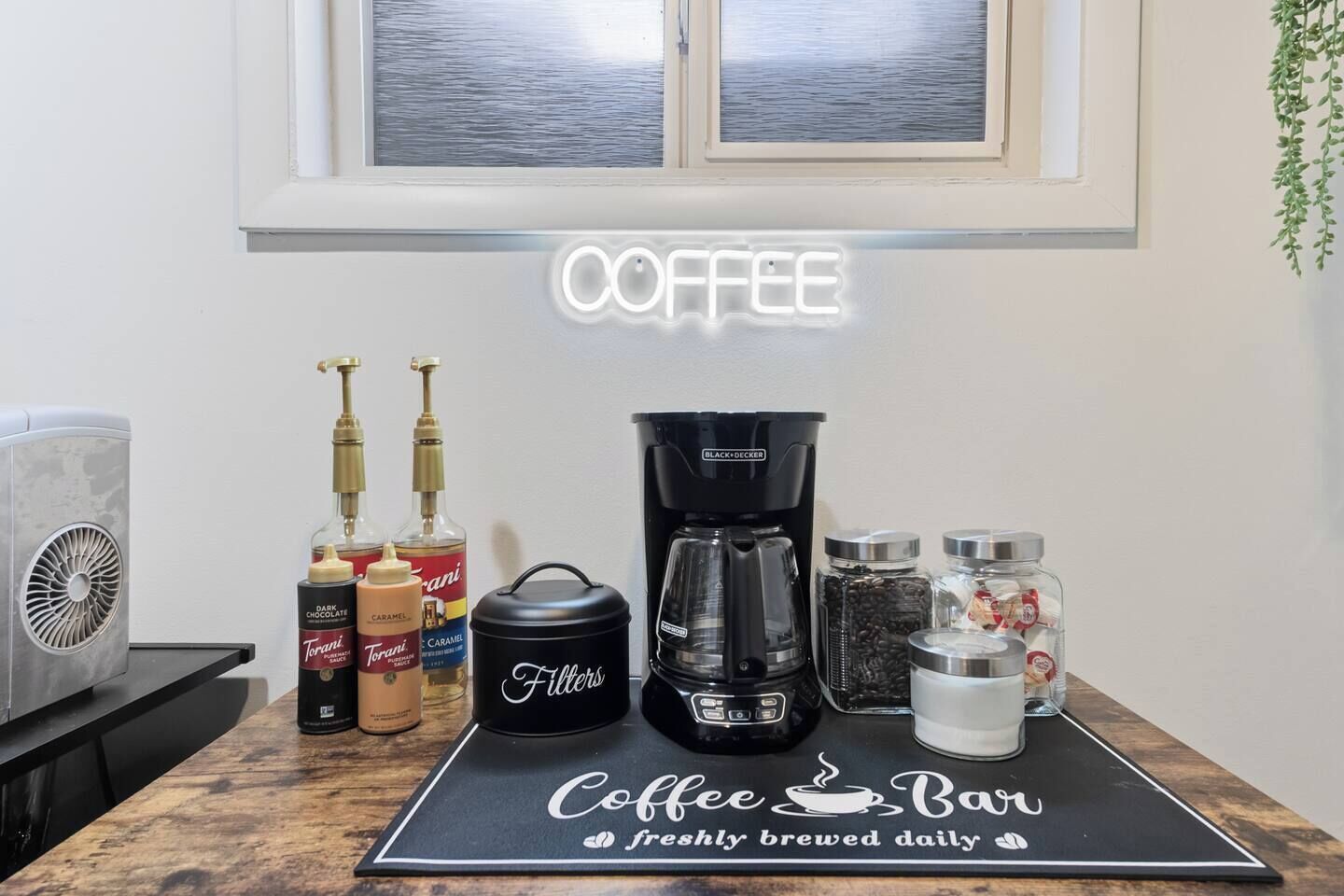 A coffee bar setup with a coffee maker, filters, and various coffee-related items on a countertop.