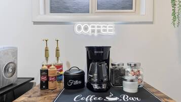 A coffee bar setup with a coffee maker, filters, and various coffee-related items on a countertop.