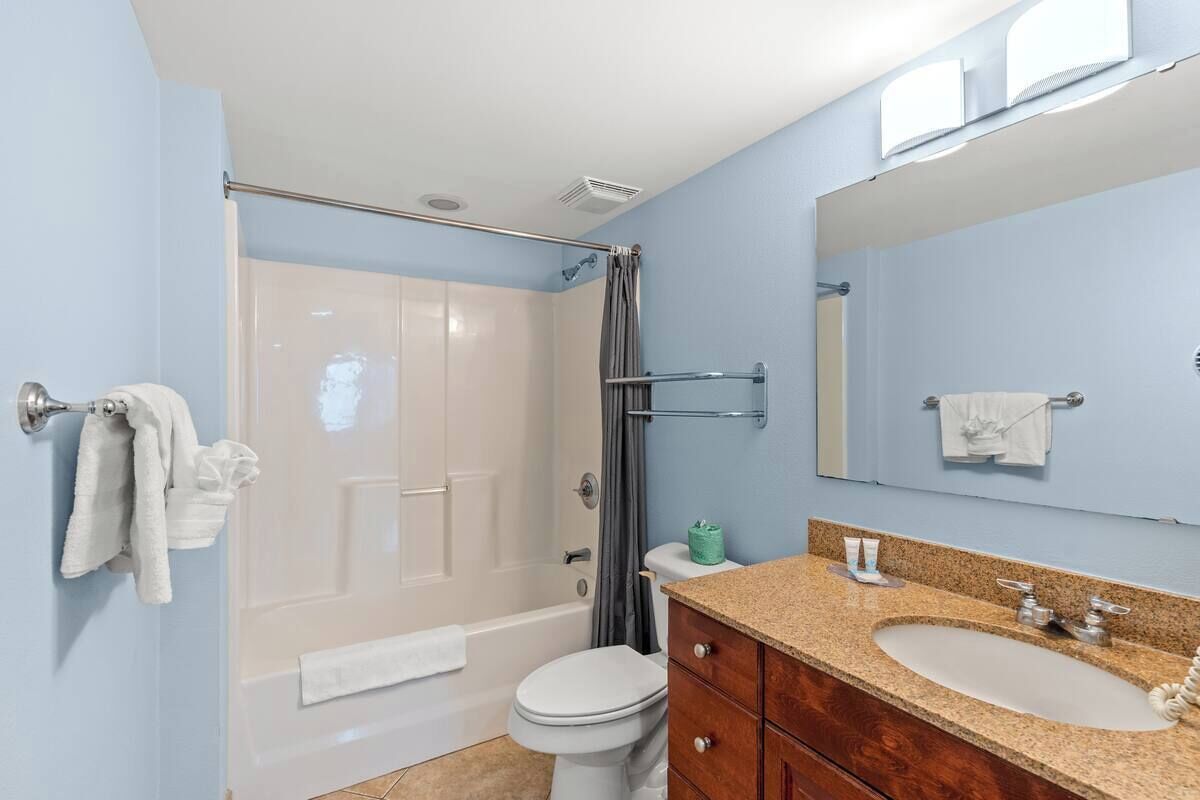A bathroom with a bathtub, toilet, and sink.