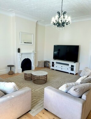 Ein Wohnzimmer mit Kamin, Fernseher und zwei Sofas.