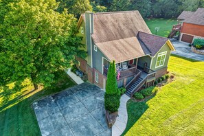 A two-story house with a front porch, a driveway, and a well-maintained lawn.
