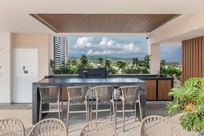 An outdoor patio with a bar and seating area, overlooking a mountainous landscape. - Maralma Bucerías Retreat | Rooftop, Pool + Terrace (Bucerías)
