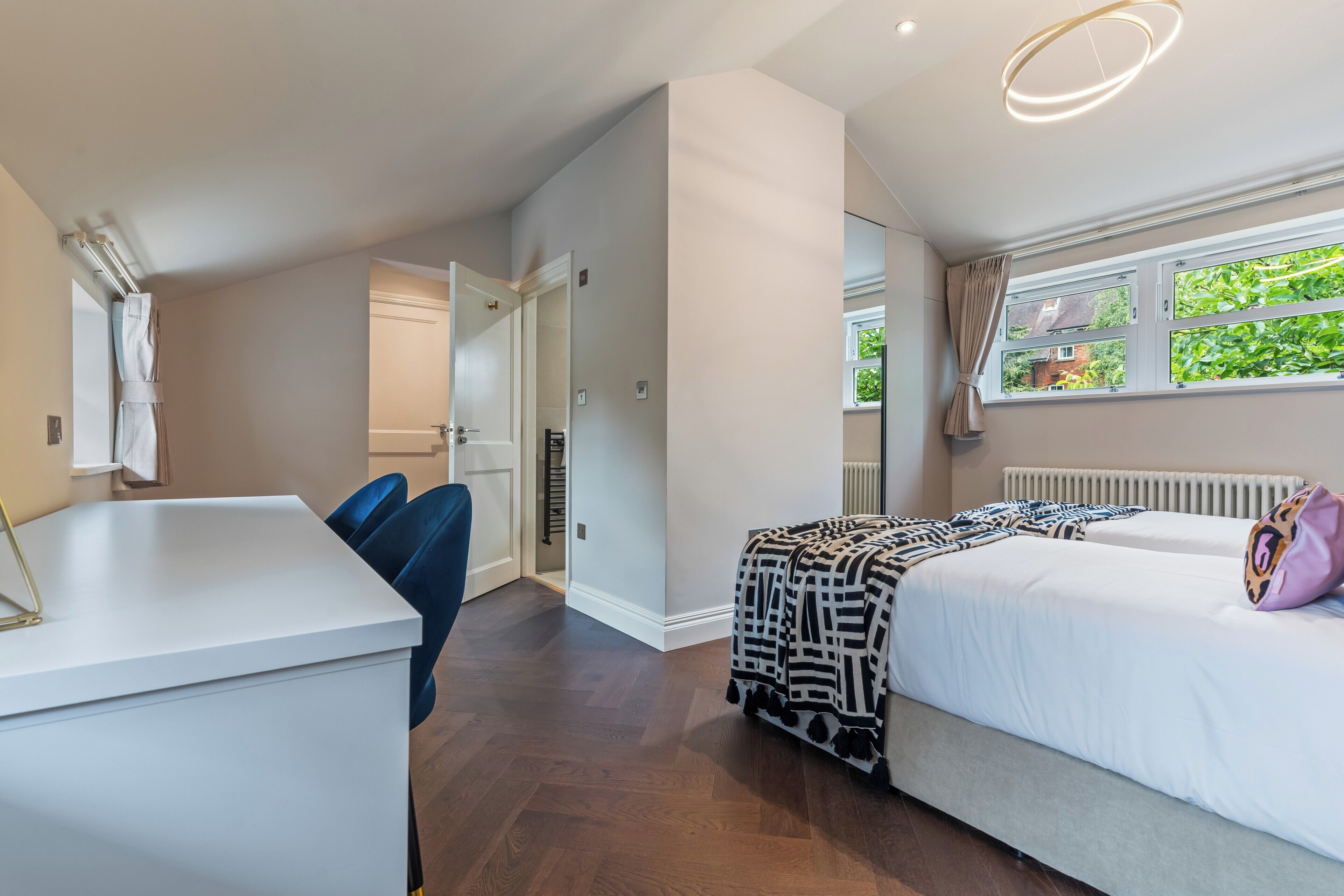 Une chambre moderne avec un lit, une table de chevet et une fenêtre avec des rideaux.