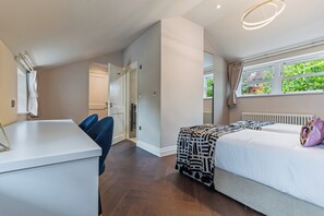 Ein modernes Schlafzimmer mit einem Bett, Nachttisch und einem Fenster mit Vorhängen.