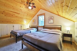 Ein Schlafzimmer mit zwei Betten, einem Deckenventilator und einem Fenster.