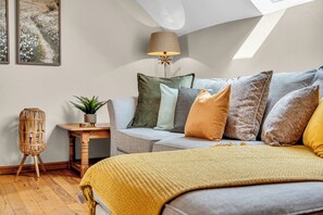 A cozy bedroom with a bed, a sofa, a small table, and a lamp. - Luxury Stay Sleeps 14 Near M 6 (Newcastle Under Lyme)