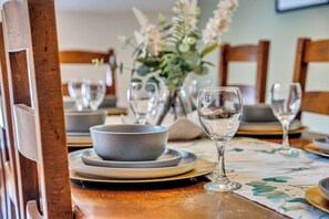 A dining table with plates, bowls, and a glass set for a meal. - Luxury Stay Sleeps 14 Near M 6 (Newcastle Under Lyme)
